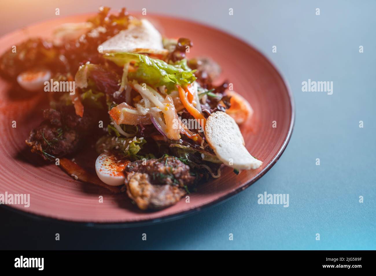 closeup of warm salad with chicken liver, egg and crouton on black background Stock Photo