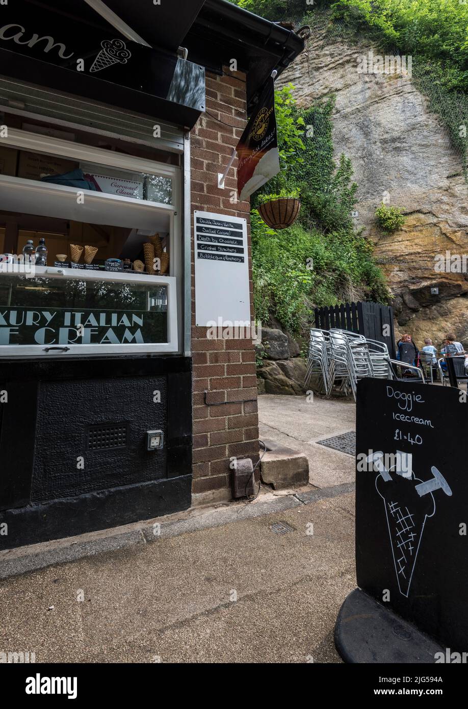 Ice cream parlour and restaurant on the banks of the River Nidd with a sign in foreground advertising it's special ice cream cones for dogs. Stock Photo