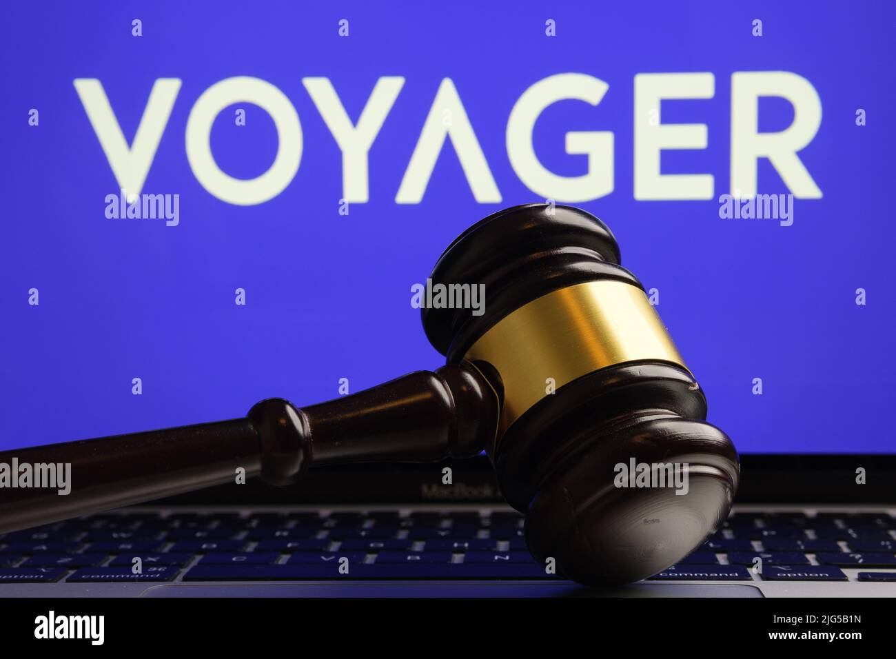 Judge's gavel seen in front and blurred Voyager Digital Ltd company logo on blurred background. Concept. Stafford, United Kingdom, July 7, 2022 Stock Photo