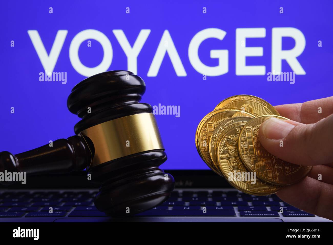 Judge's gavel and crypto coins in front and blurred Voyager Digital Ltd company logo on blurred background. Concept. Stafford, United Kingdom, July 7, Stock Photo