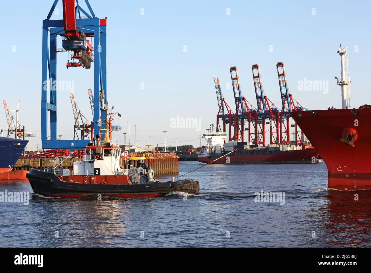 tug pulls cargo ship into the port of hamburg Stock Photo