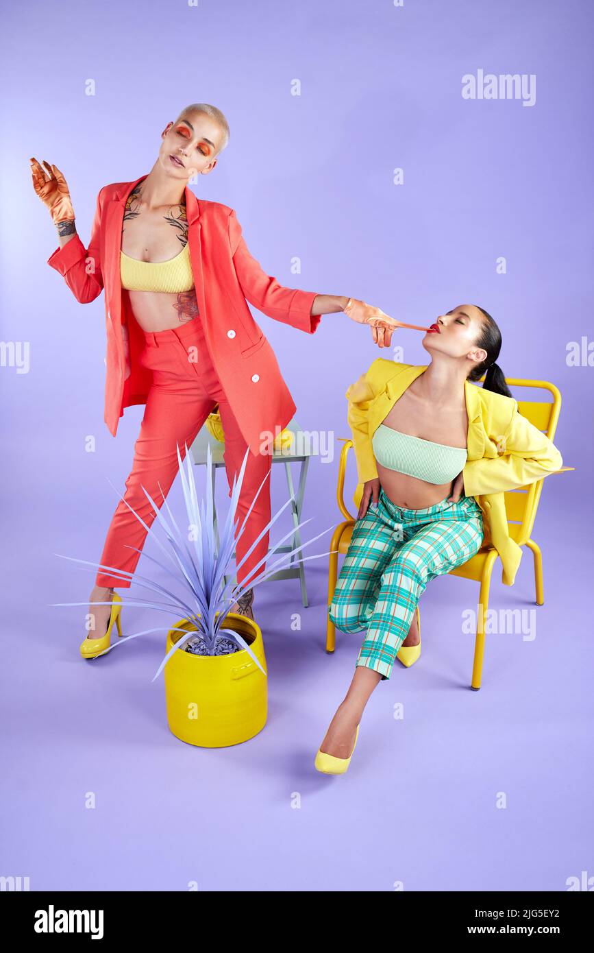 Our differences make us unique. Full length studio shot of two attractive young women dressed in funky attire against a purple background Stock Photo Alamy