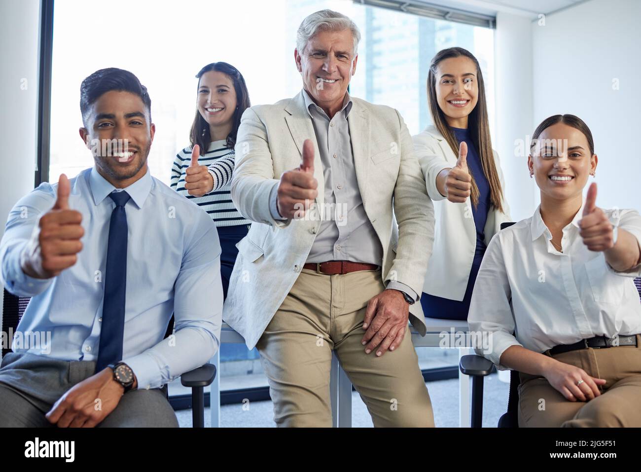 Were doing great things. Shot of a group of businesspeople showing thumbs up at the office. Stock Photo