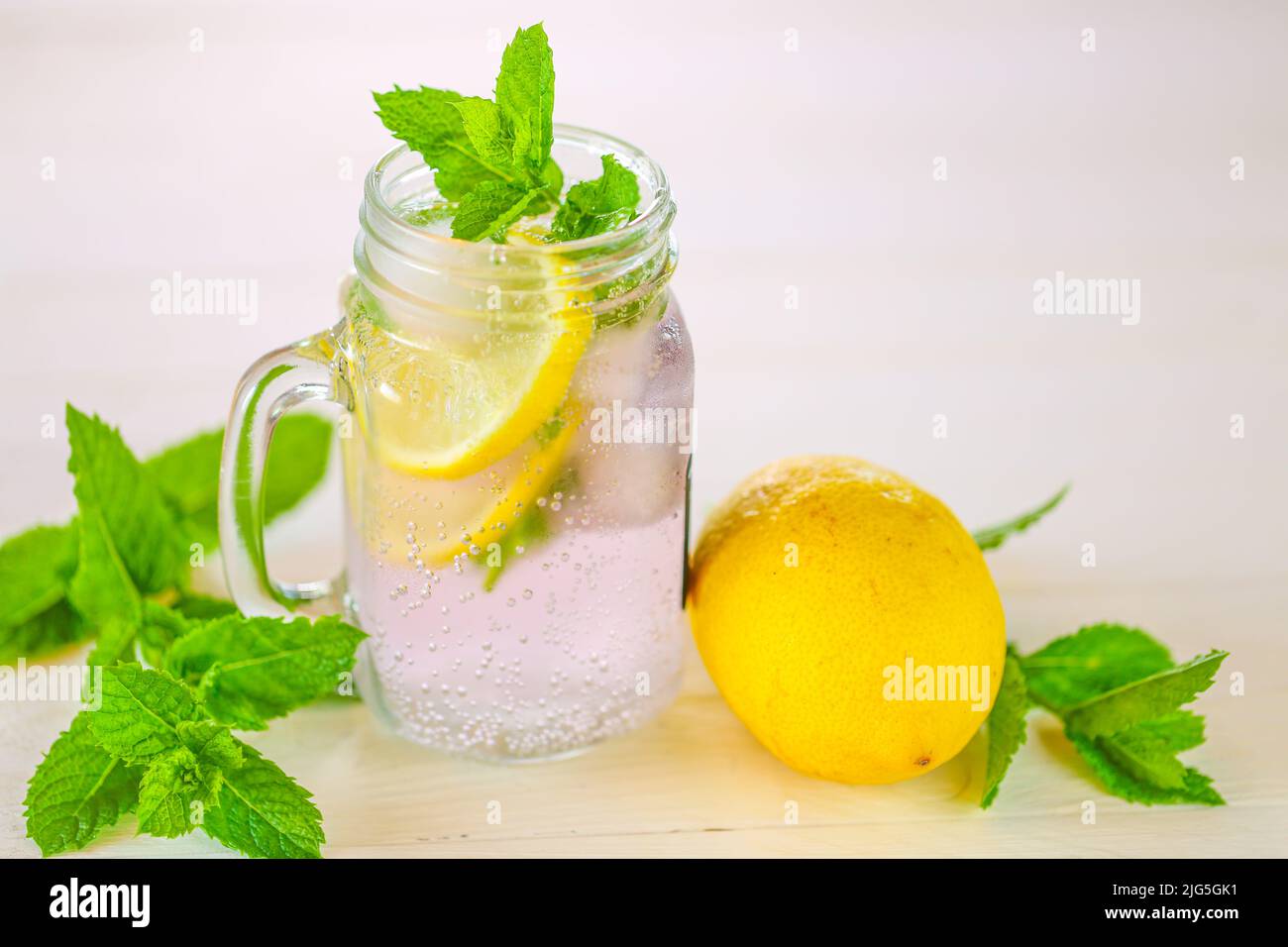 Lemon mint water with ice in a transparent mug.Citrus cocktail with
