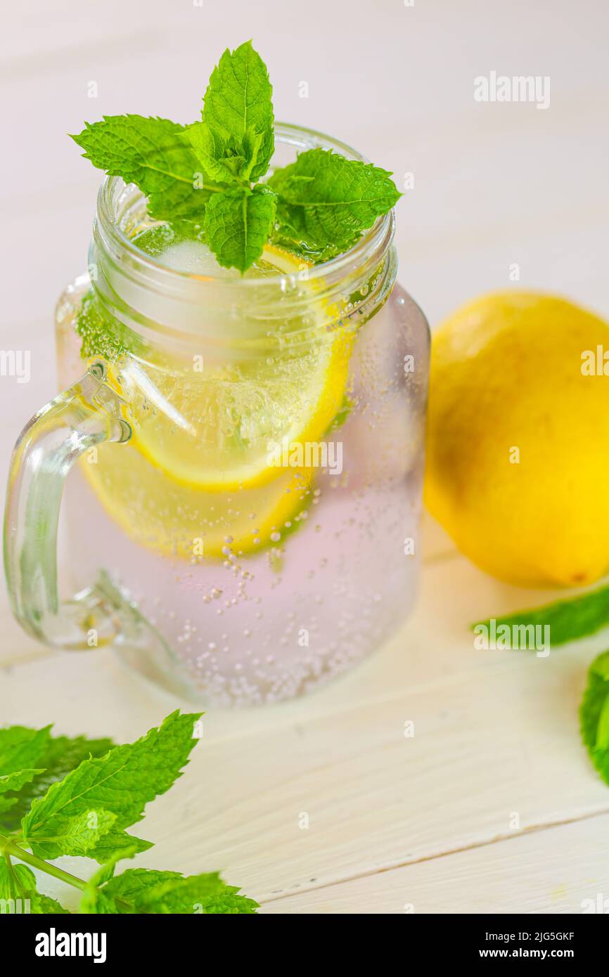 Lemon mint water.Citrus cocktail with mint leaves. Sassy lemon water.Lemon drink.Dietary lemon drink.Sprig of mint in a glass with a cocktail. Stock Photo
