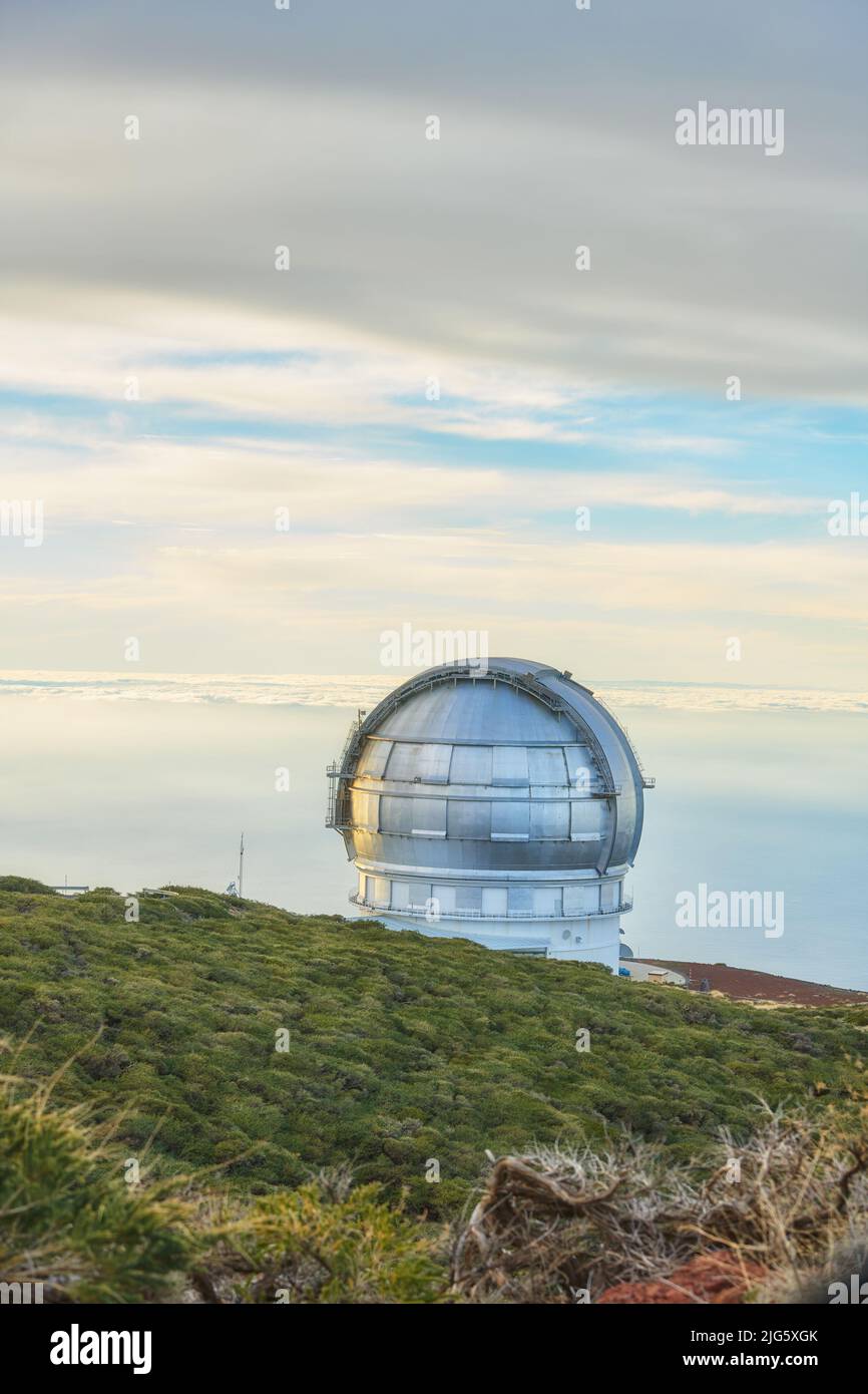 Scenic view of an astronomy observatory dome in Roque de los Muchachos, La Palma, Spain. Landscape of science infrastructure or building against blue Stock Photo