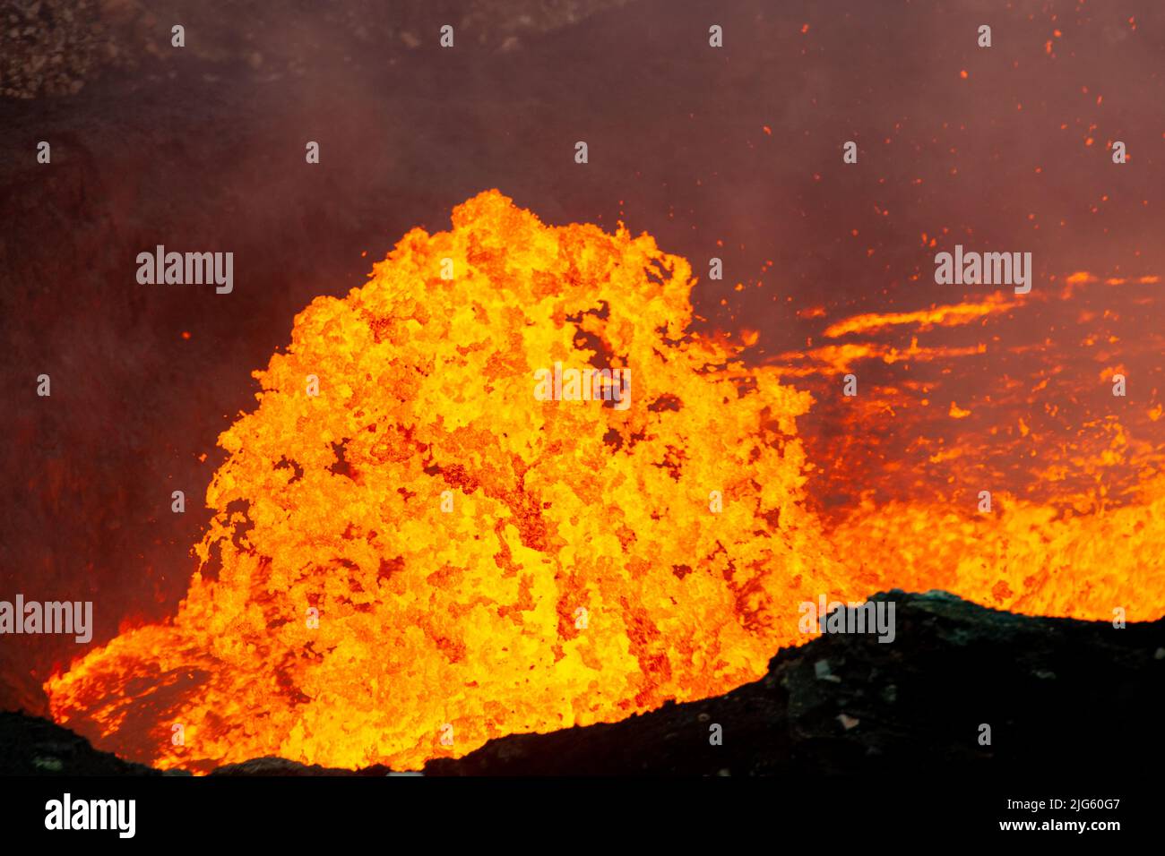 A burst of lava shoots out of the lava lake inside the Marum vent during an expedition to the volcano on Ambrym island in Vanuatu. Stock Photo