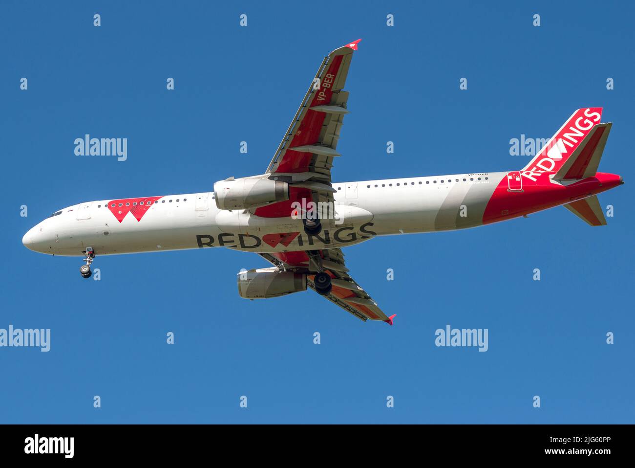 SAINT PETERSBURG, RUSSIA - AUGUST 08, 2020: Aircraft Airbus A321-200 (VP-BER) of Red Wings airline on glide path in cloudless blue sky. Bottom view Stock Photo