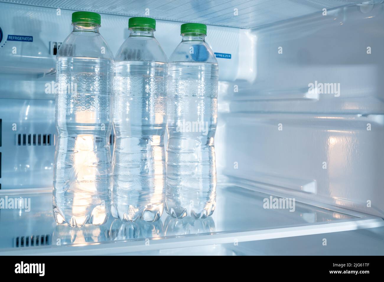 Cold bottles of clean drinking water in a white refrigerator Stock Photo