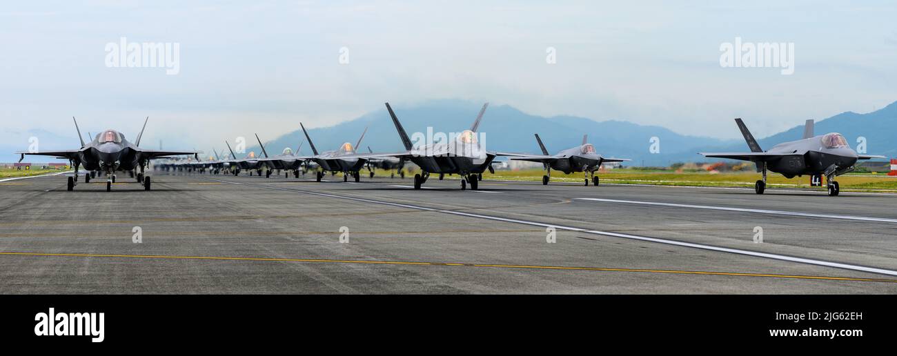The U.S. Air Force 354th Air Expeditionary Wing and Marine Aircraft Group 12 performed a capabilities demonstration during a pre-planned readiness exercise at Marine Corps Air Station Iwakuni, Japan, July 7, 2022. The demonstration included five U.S. Marine Corps F/A-18 Hornets, eight F-35B Lightning IIs, a KC-130J Super Hercules aircraft, 10 U.S. Air Force F-22 Raptors and 10 F-35A Lightning II aircraft, showcasing a high level of readiness and joint service capability in support of a free and open Indo-Pacific. (U.S. Air Force photo by Senior Airman Jose Miguel T. Tamondong) Stock Photo