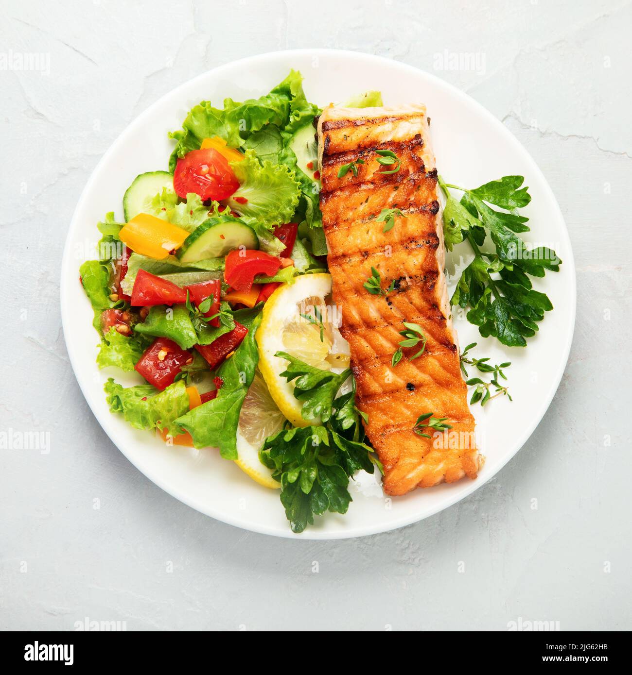 Salmon steak with vegetables and fries on light background. Freshly ...