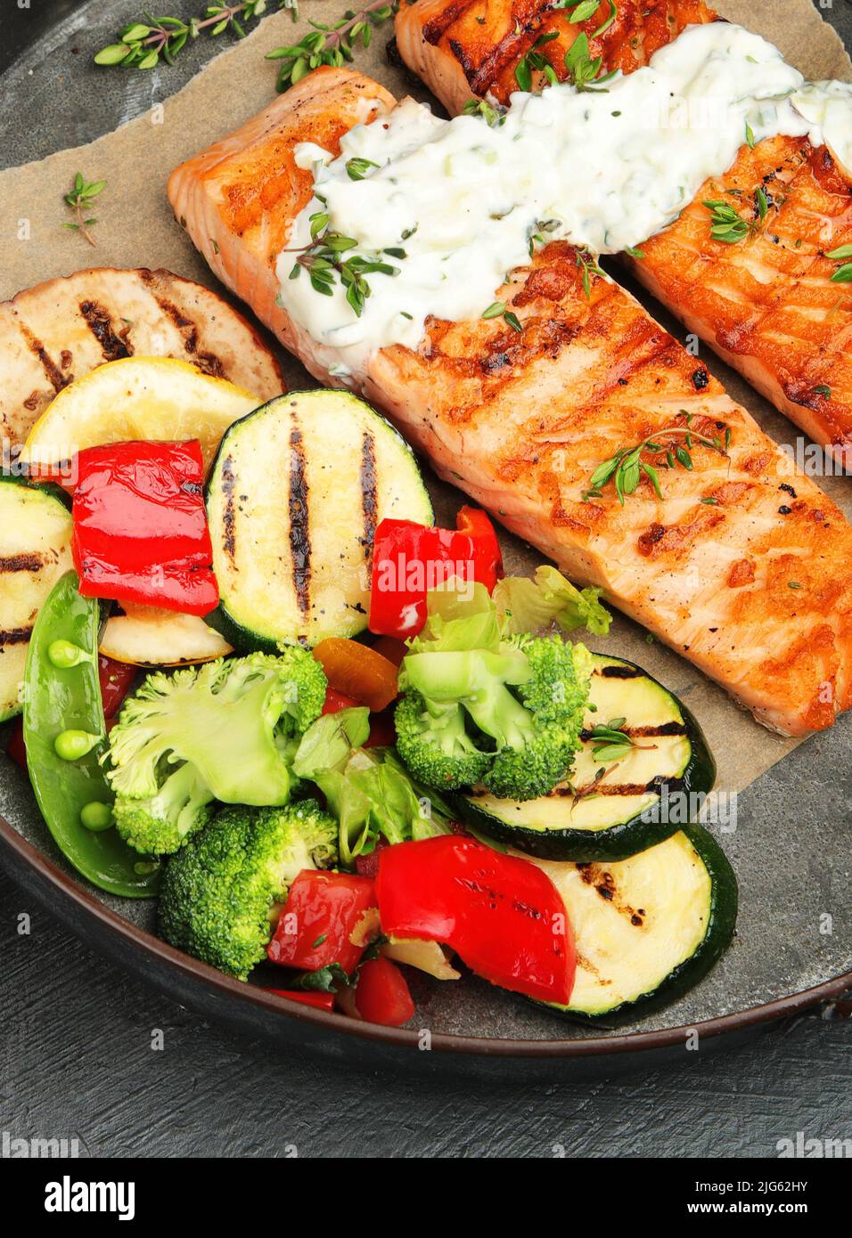 Salmon steak with vegetables on dark background. Freshly grilled ...