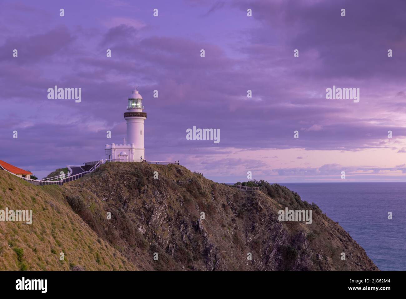 a wide angle view of the historic lighthouse at sunrise on a spring morning at byron bay Stock Photo