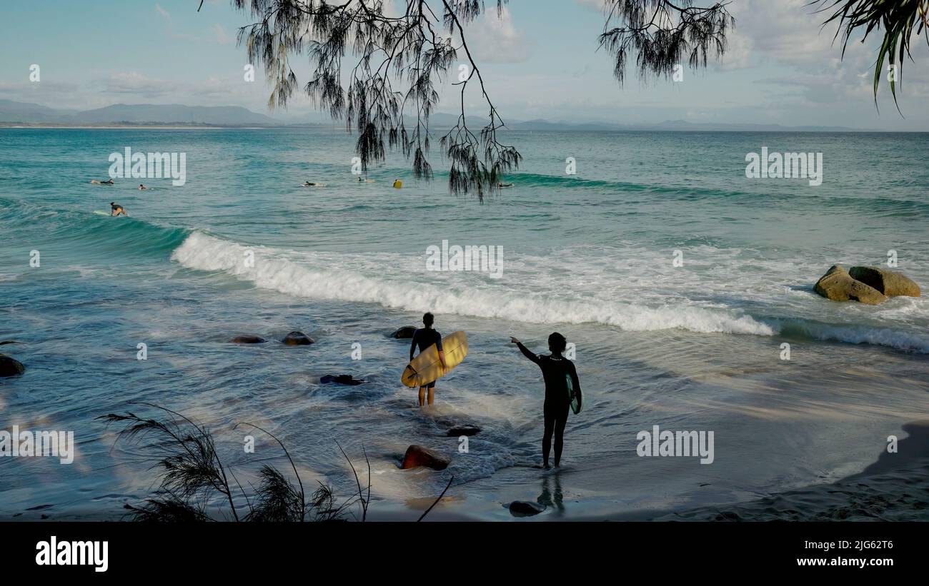 BYRON BAY, AUSTRALIA - NOV 3 2021: two longboard surfers check out the waves at wategos beach of byron bay Stock Photo