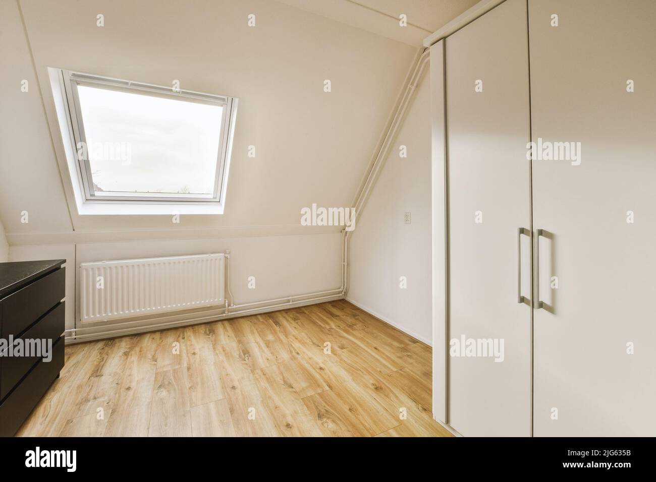 Interior of spacious apartment room on attic of building furnished with