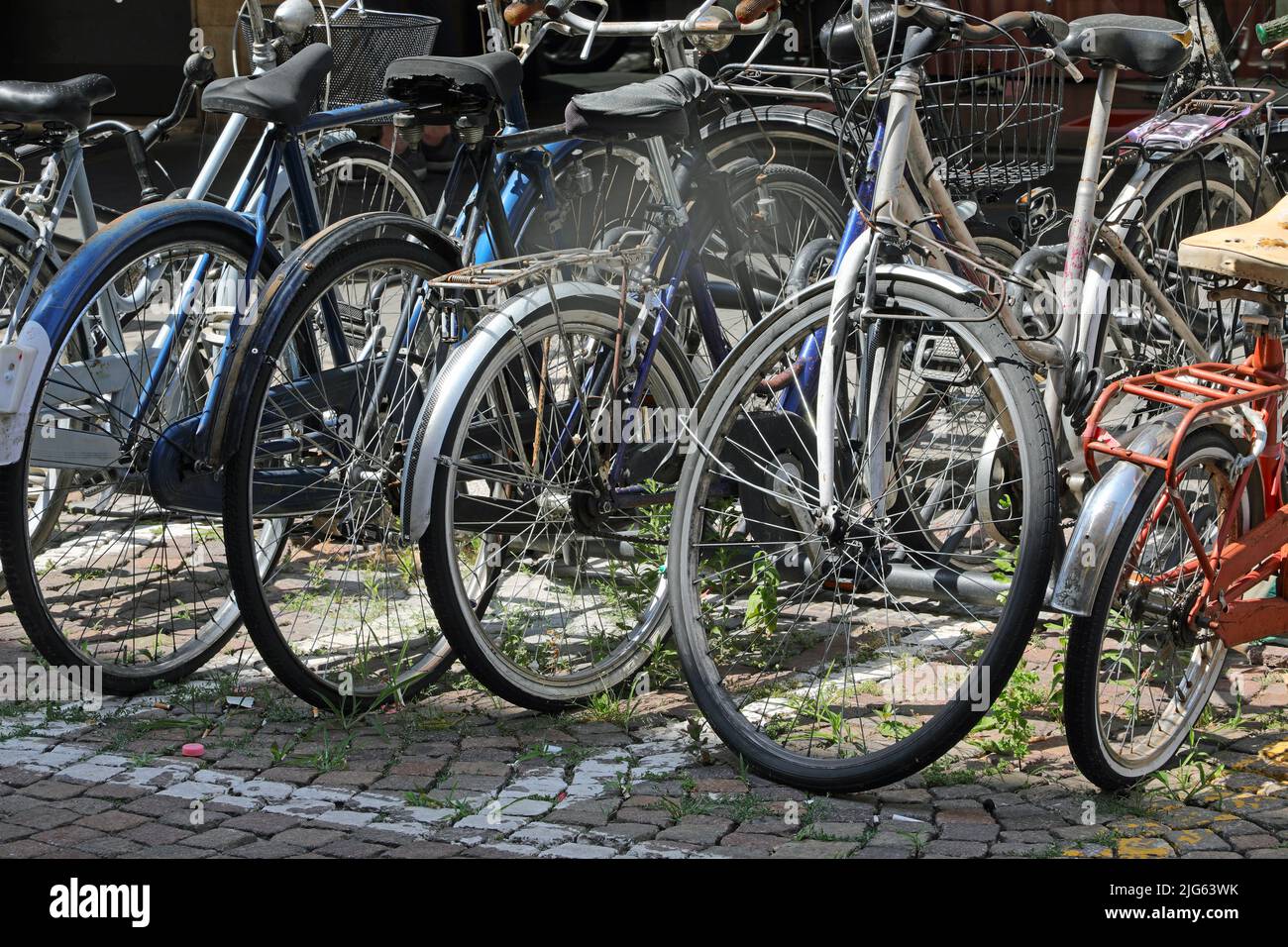 many old bicycles parked in the parking lot near the university used by students to move around the city Stock Photo