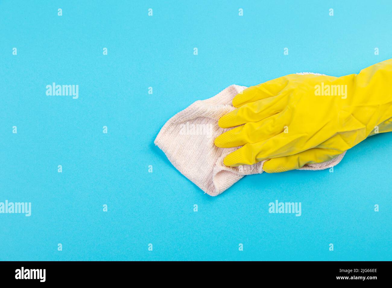 worker's hand in a yellow rubber protective glove with a pink-beige ...