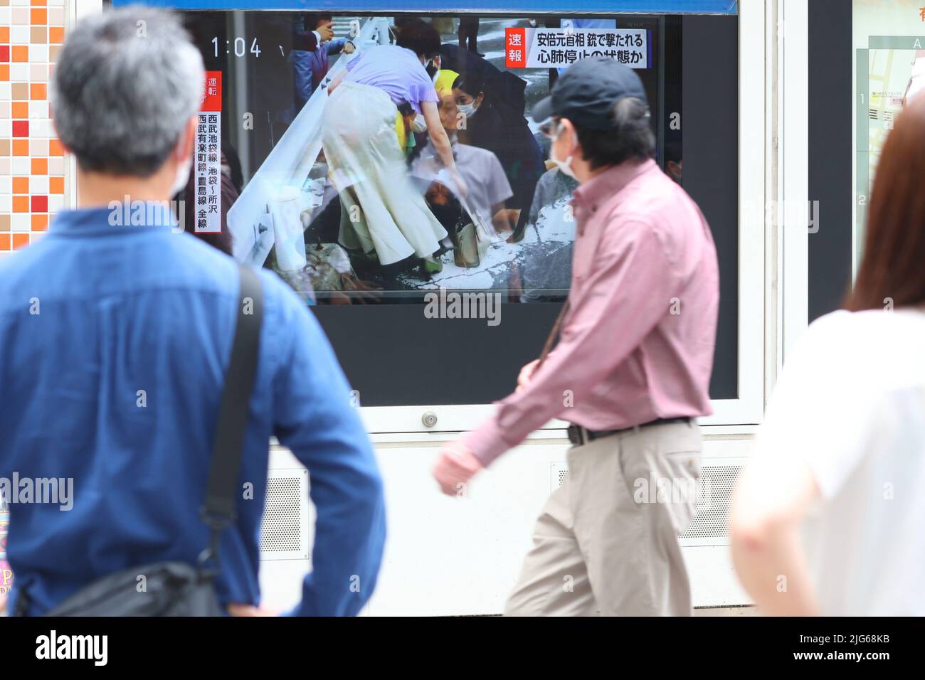 Abe Shot Pedestrians watch a large screen reporting Japan's former Prime ...