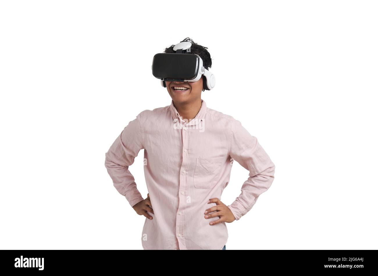 Young peruvian man laughing wearing virtual reality headset, isolated. Stock Photo
