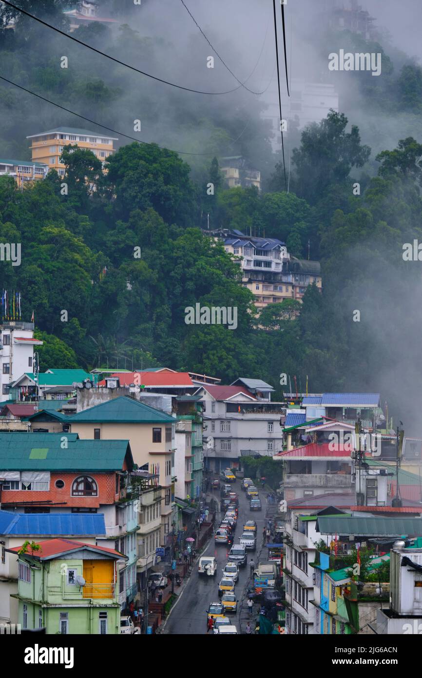 Gangtok, Sikkim - June 16 2022, Tourists enjoy a ropeway cable car ride over Gangtok city. Amazing aerial cityscape of Sikkim. covered in mist or fog. Stock Photo