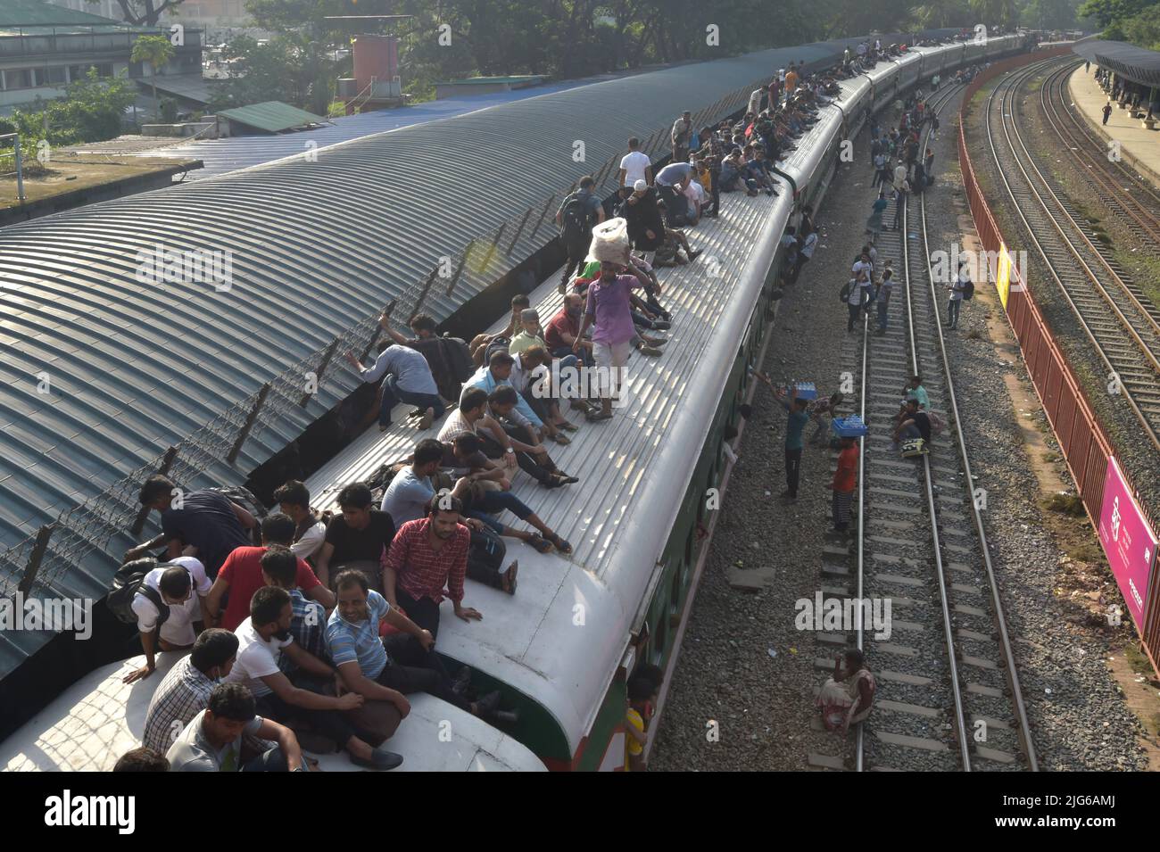 Dhaka. 8th July, 2022. Travelers sitting on the roof of a train leave a station in Dhaka, Bangladesh, July 7, 2022. As Eid al-Adha festival approaches, many people from Bangladesh capital Dhaka have streamed out of the city to join the festival with their kith and kin in village homes. Credit: Xinhua/Alamy Live News Stock Photo