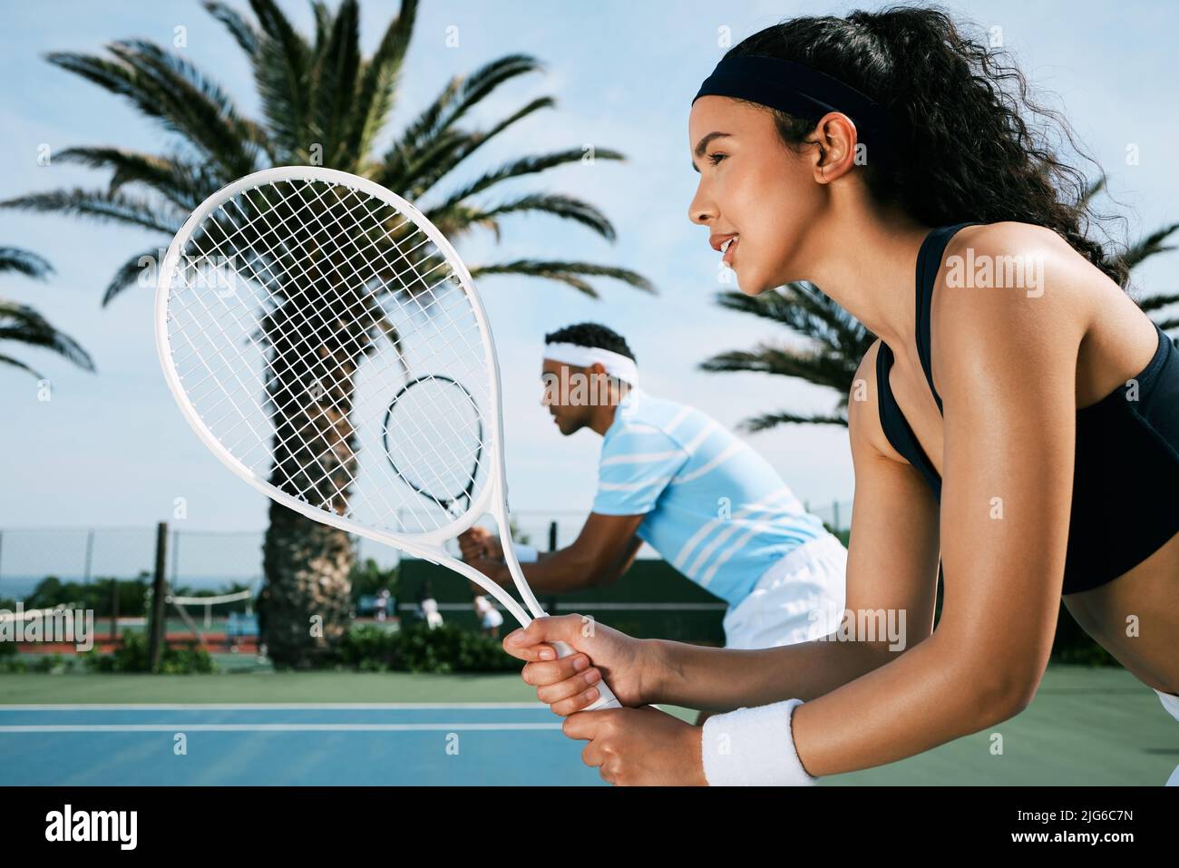 We got this. Shot of an attractive young woman standing and playing tennis with her teammate. Stock Photo