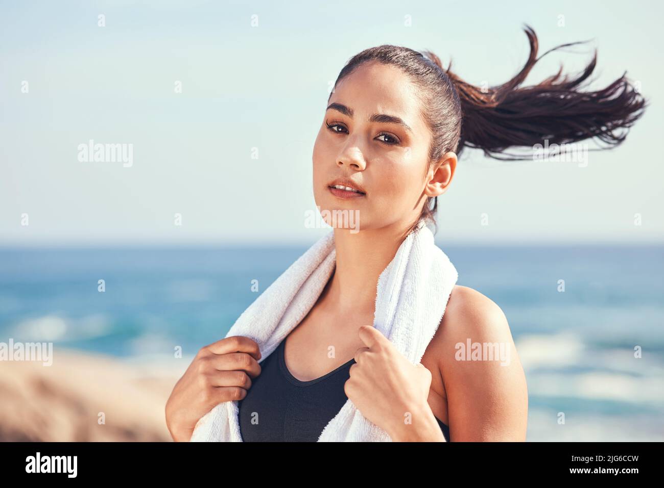Ready to mop up some sweat. Shot of a young woman taking a break during a workout. Stock Photo