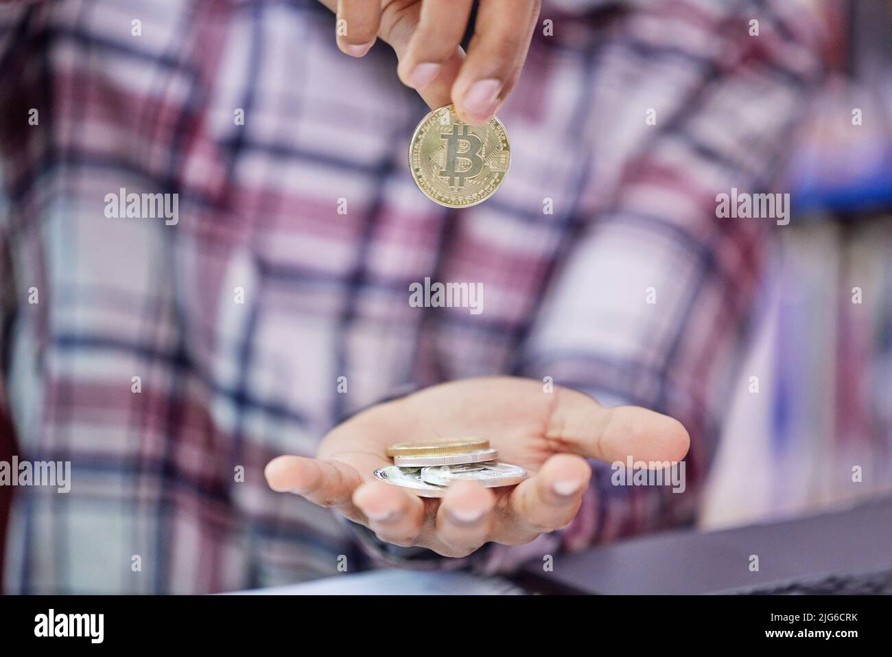 How much is it worth to you. Shot of an unrecognisable man holding bitcoins. Stock Photo