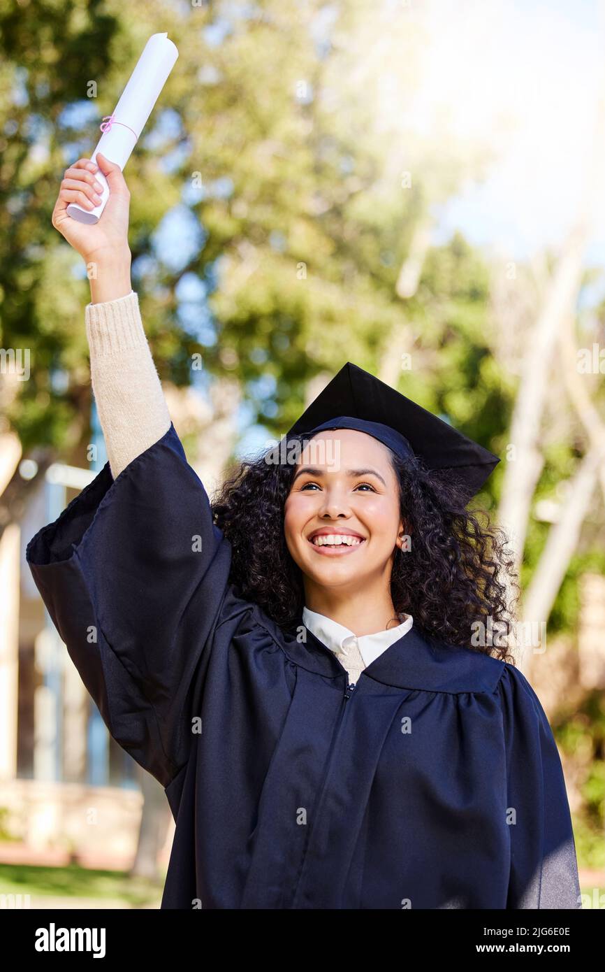 Up, up and away. Shot of a young woman cheering on graduation day. Stock Photo