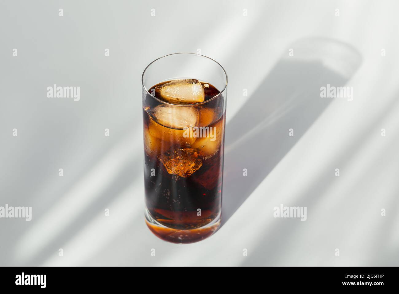 Glass of cola with ice on white background Stock Photo - Alamy