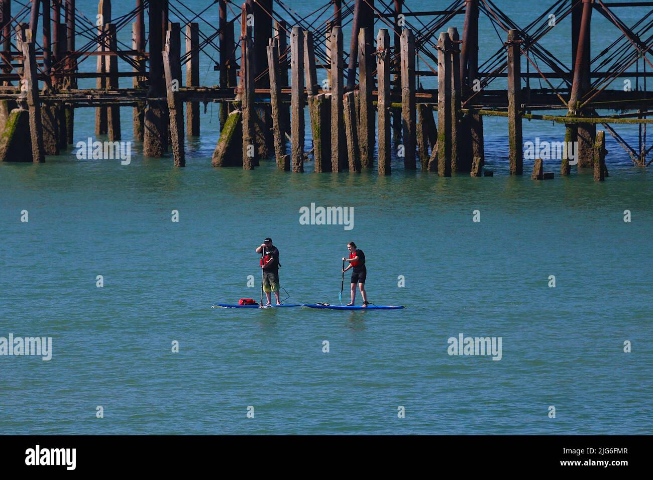 Hastings, East Sussex, UK. 08 Jul, 2022. UK Weather: Very hot and sunny at the seaside town of Hastings in East Sussex as Brits enjoy the very hot weather today and is expected to reach 29c in some parts of the UK. Paddle boarders near the pier in Hastings. Photo Credit: Paul Lawrenson /Alamy Live News Stock Photo