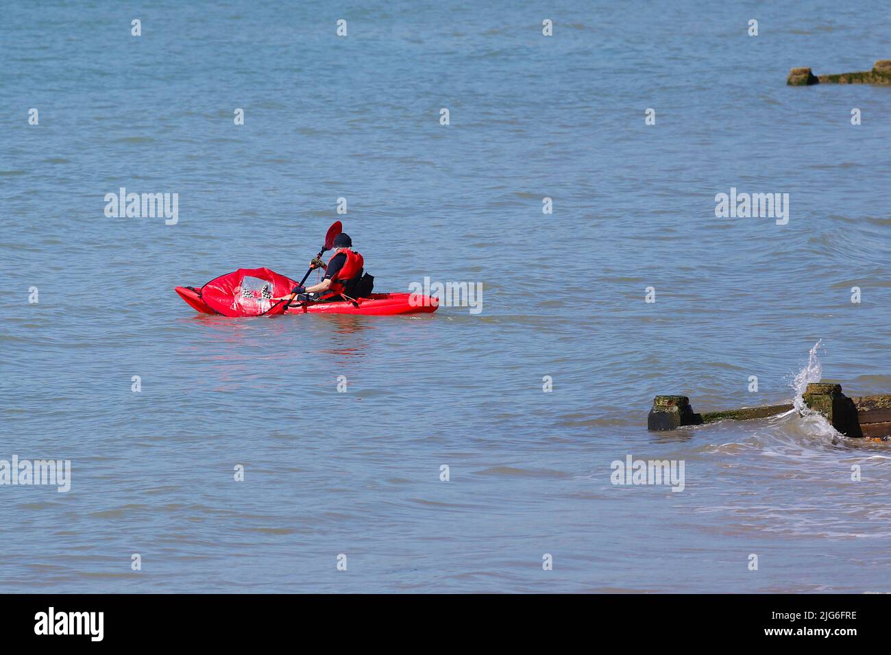 Hastings, East Sussex, UK. 08 Jul, 2022. UK Weather: Very hot and sunny at the seaside town of Hastings in East Sussex as Brits enjoy the very hot weather today and is expected to reach 29c in some parts of the UK. A kayaker heads out to sea. Photo Credit: Paul Lawrenson /Alamy Live News Stock Photo