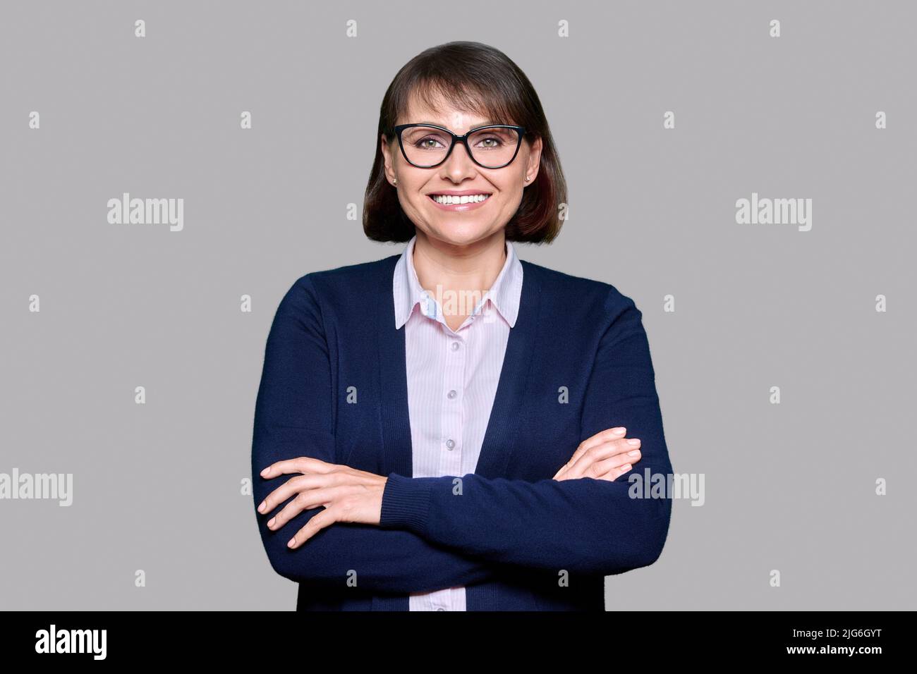 Middle aged smiling business woman over gray isolated background Stock ...