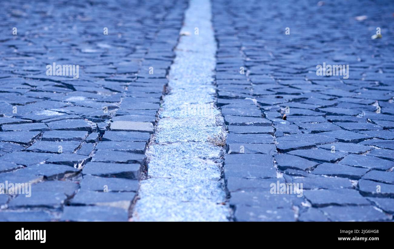 Paving stones. Cobblestone pavement divided by a granite strip close-up Stock Photo