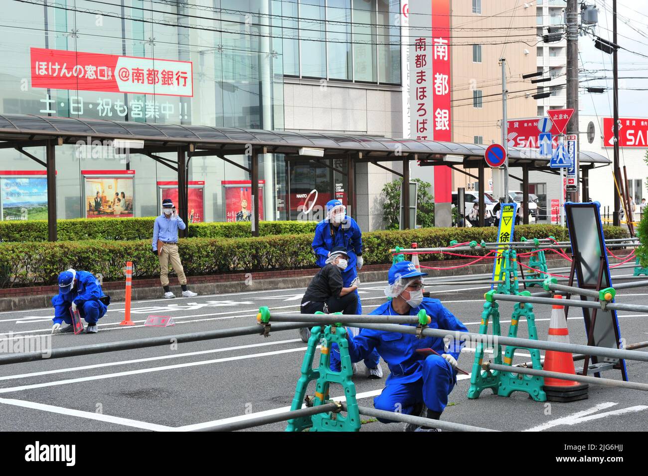Police officers investigate the scene where Japan's former Prime ...