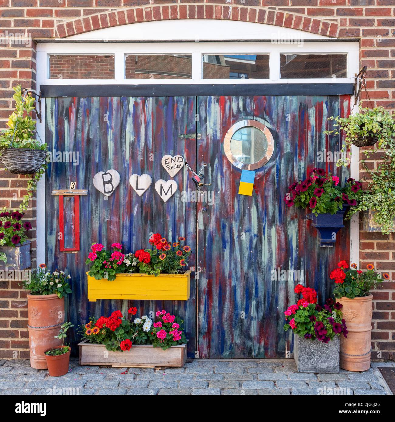 Black Lives Matter, End Racism signs or messages on colourful painted doors with flowers Stock Photo