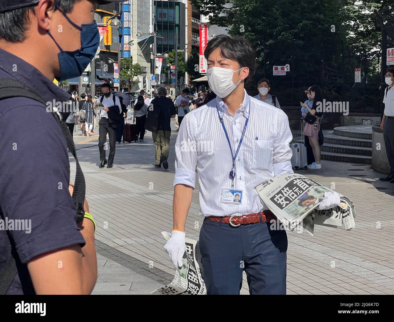 Tokyo, Japan. 8th July, 2022. A staff member distributes copies of an extra edition of the Yomiuri Shimbun newspaper reporting on the shooting of former Japanese Prime Minister Shinzo Abe, on a street in Tokyo, Japan, July 8, 2022. Credit: Sun Jialin/Xinhua/Alamy Live News Stock Photo