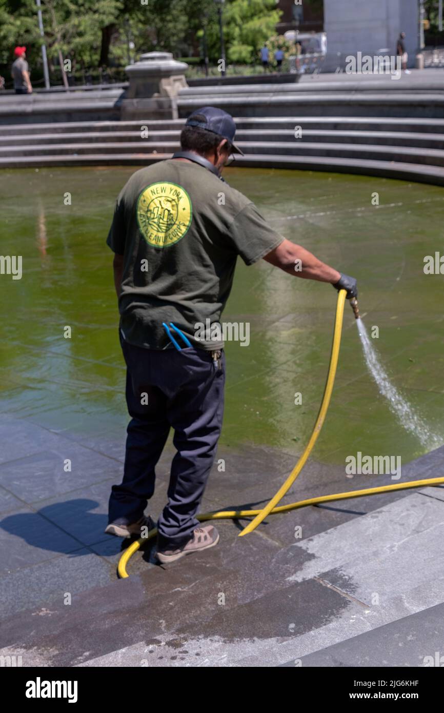 A man from the New York City Cleanup Corps cleans the fountain in Washington Square Park in Greenwich Village, Manhattan, New York City. Stock Photo