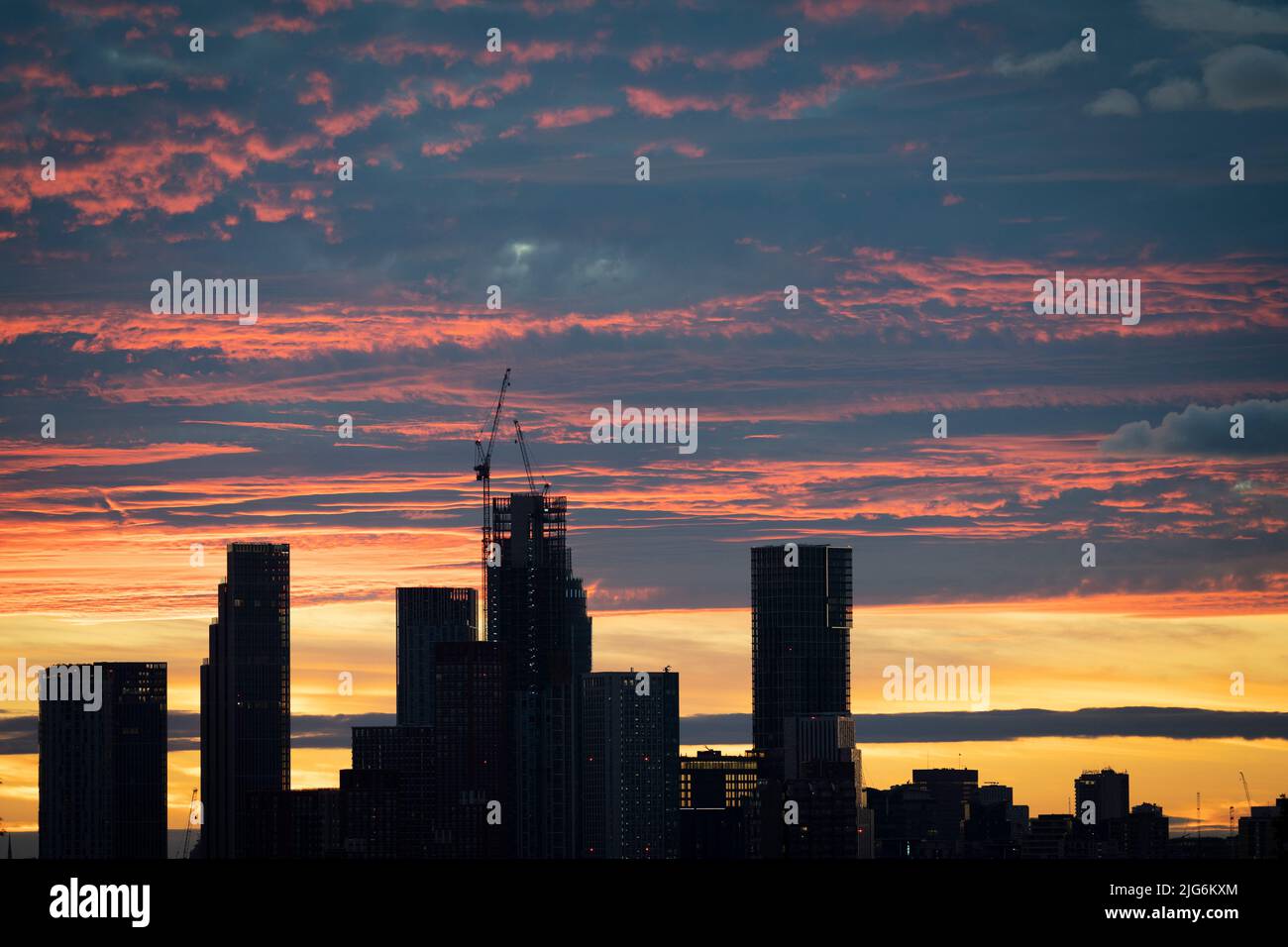 High-rise residential towers at Nine Elms in Battersea are seen from a distance across south London beneath dramatic sunset clouds, on 6th July 2022, in London, England. Stock Photo