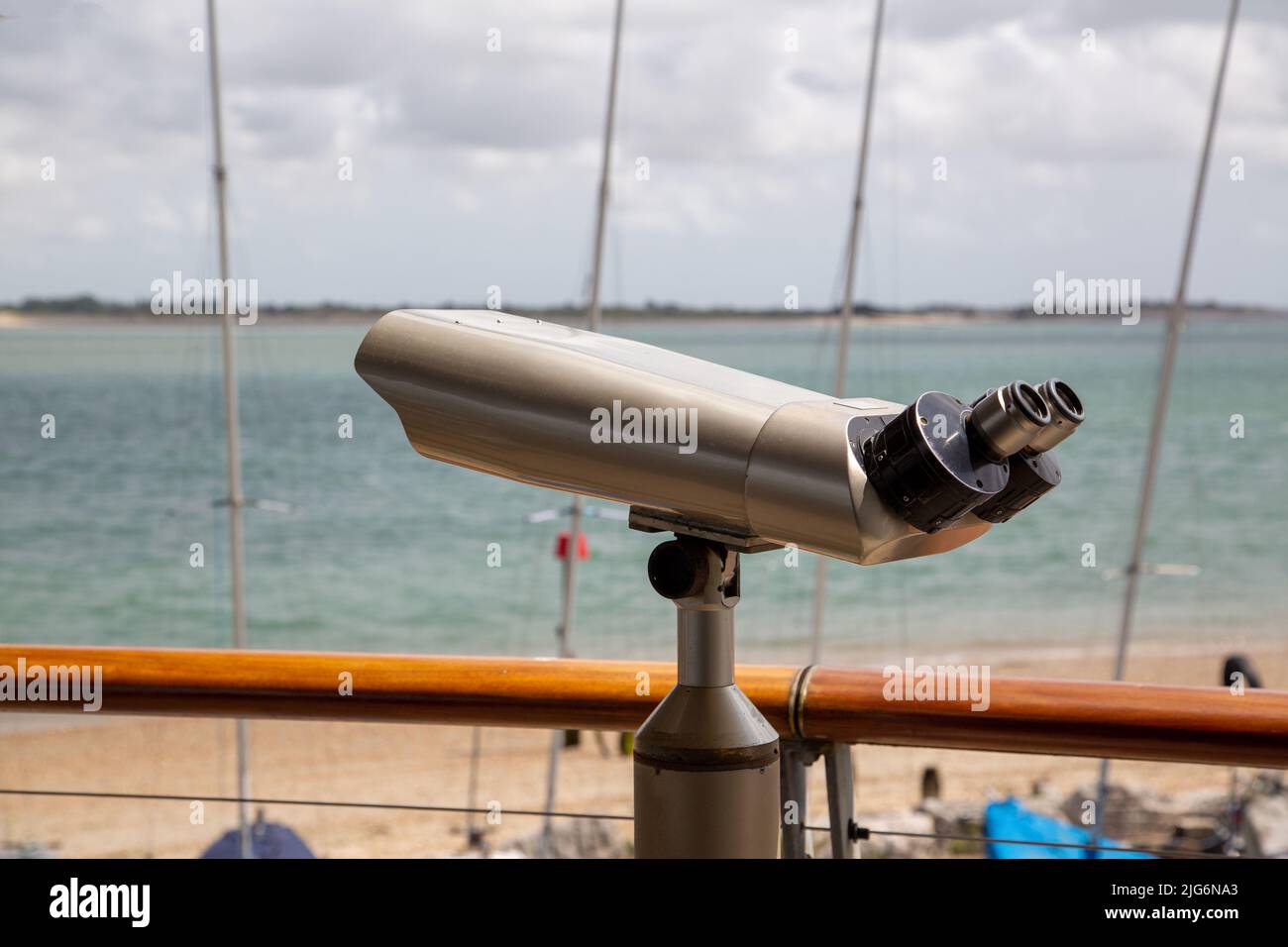 A mounted telescope on a balcony looking out to sea Stock Photo