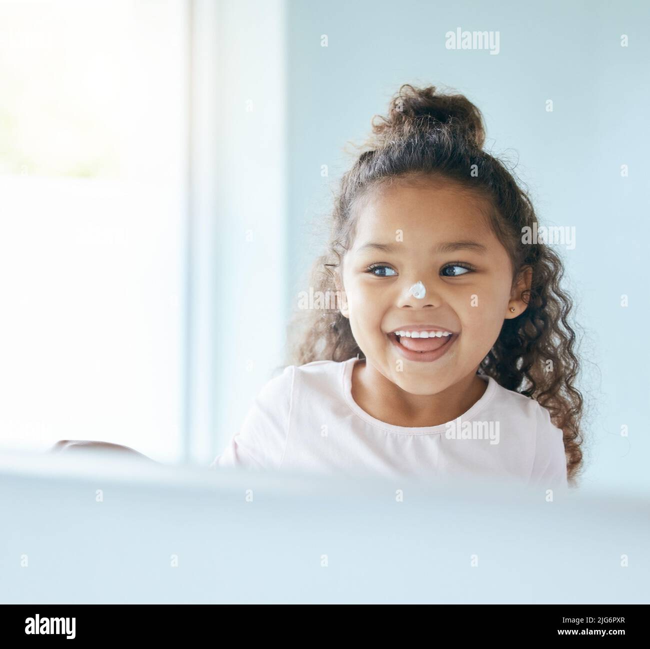 Learning to use sunscreen at a young age. Shot of a little girl