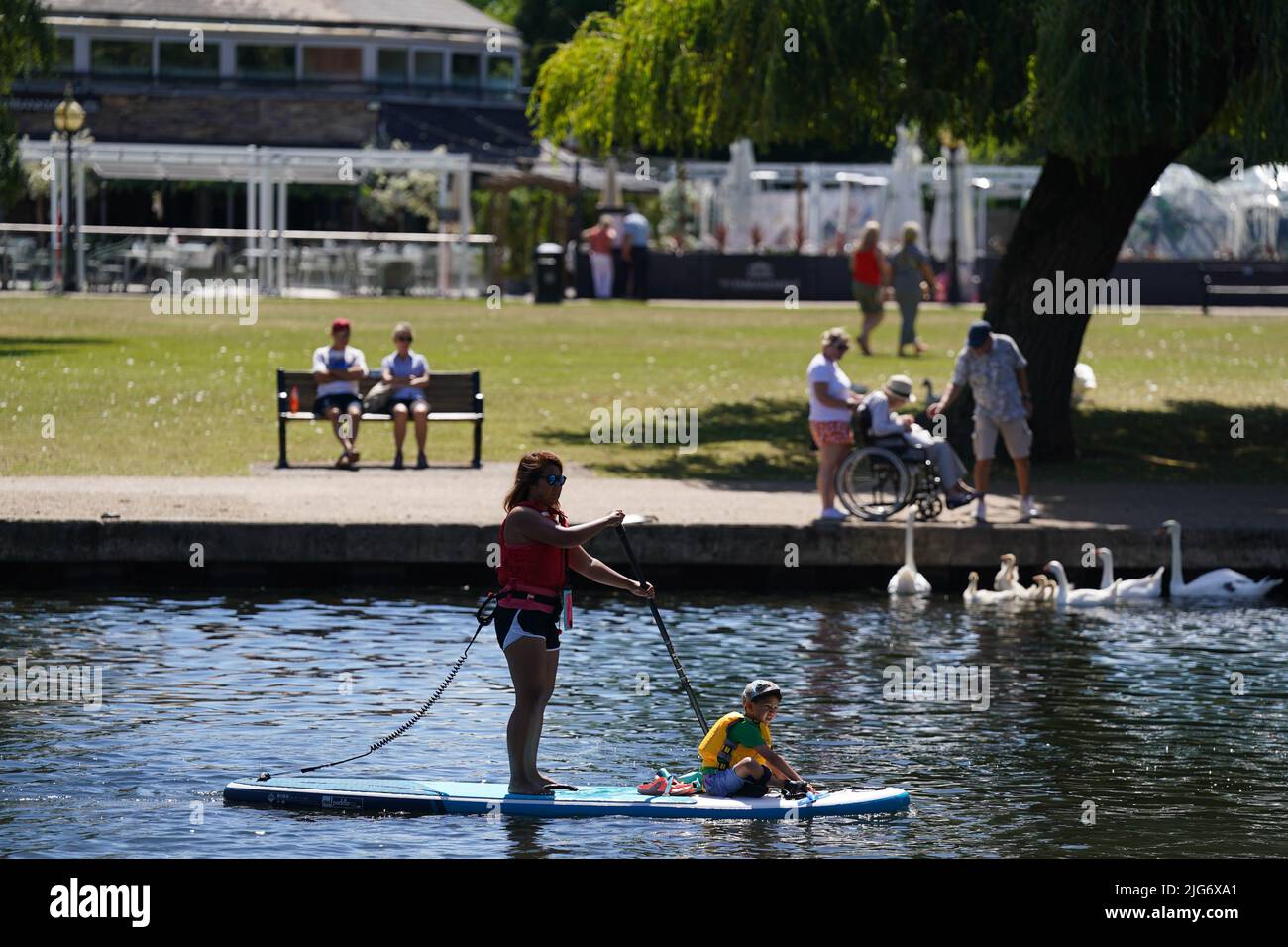 A woman and a child on a paddle board on the river Avon in Stratford