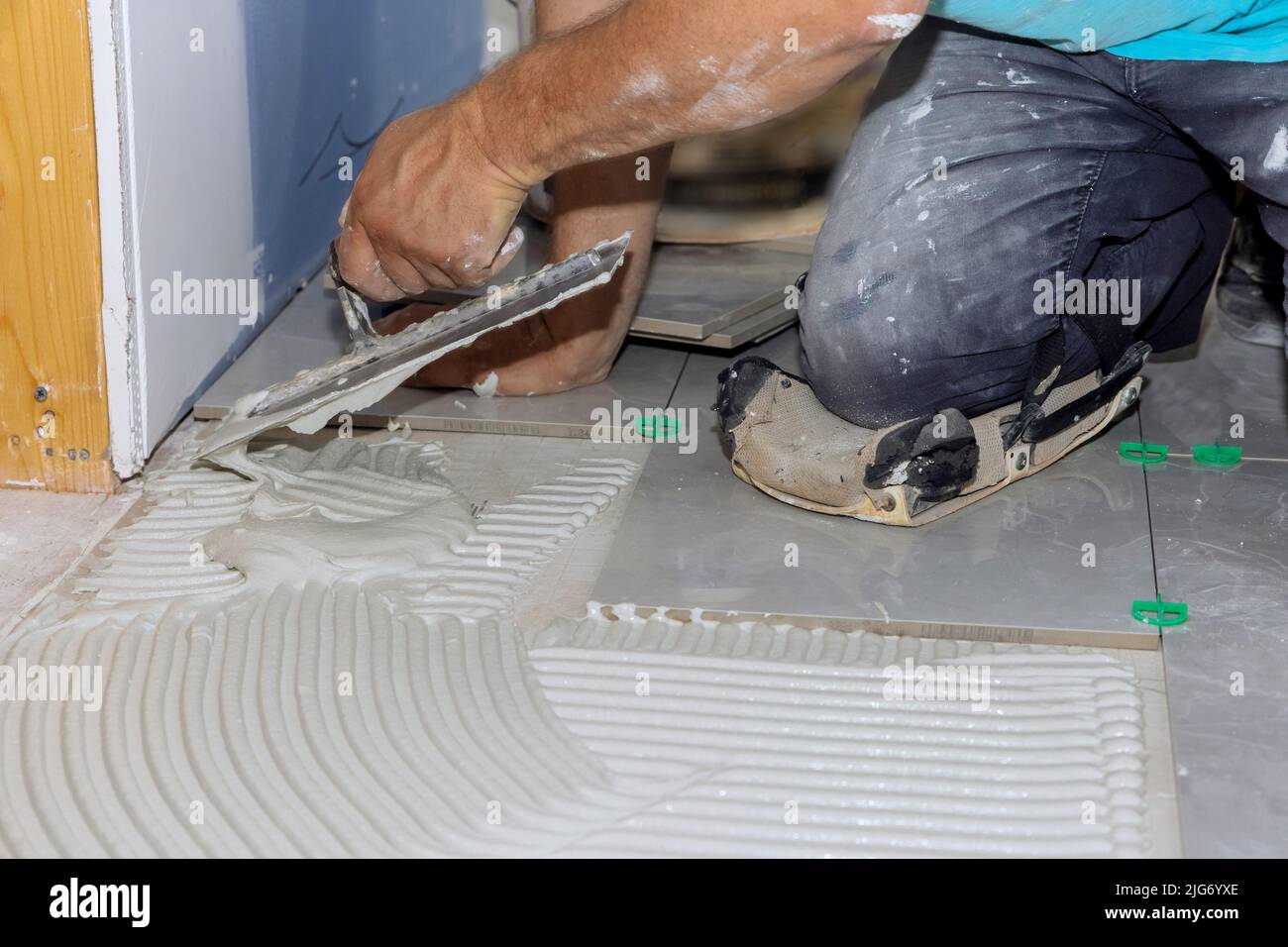 To put adhesive on tiles, spread wet mortar first Stock Photo Alamy