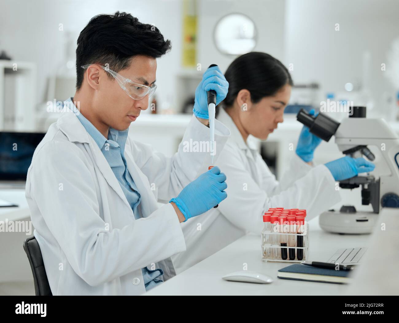 Time to send this off to the lab. Shot of a young man filling a test tube in a lab. Stock Photo