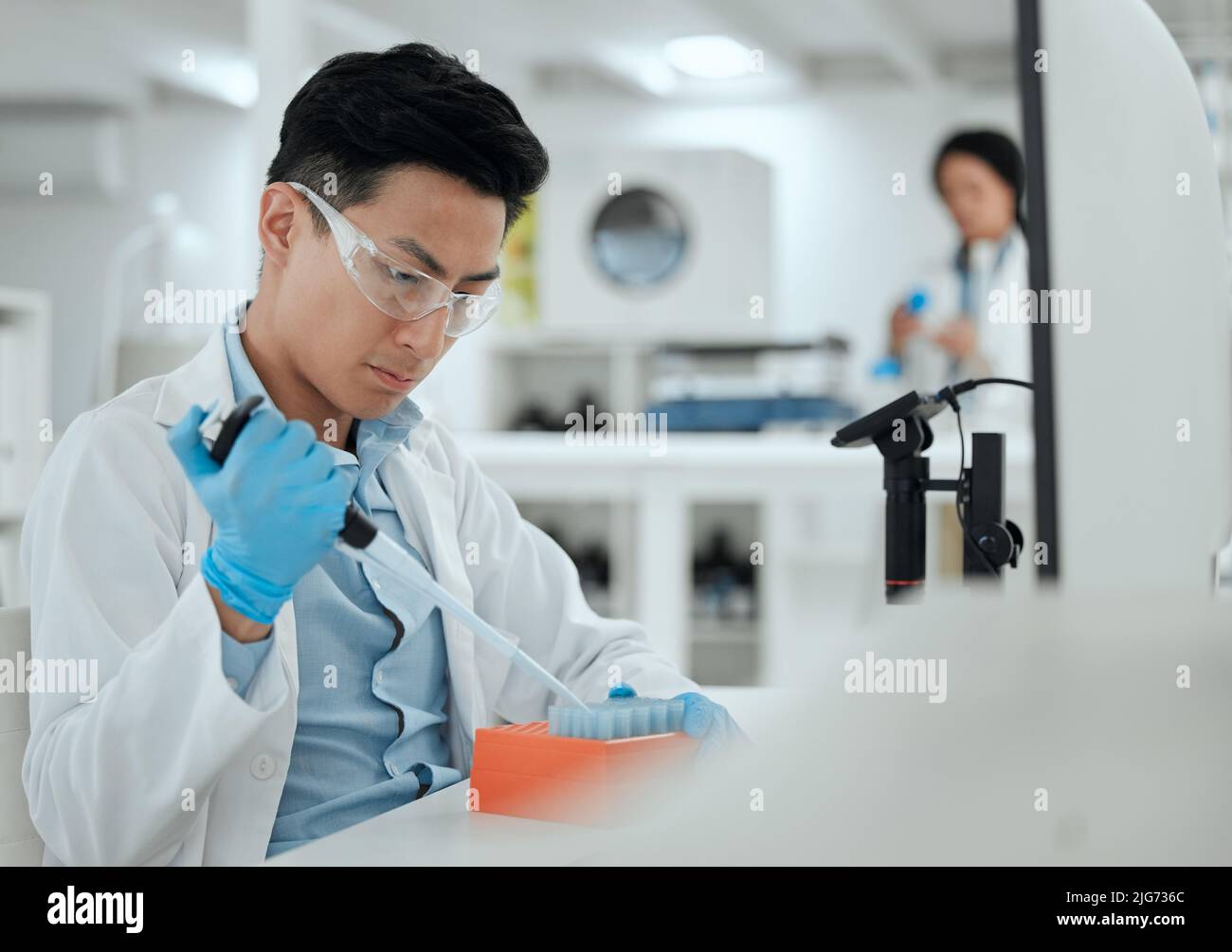 Being careful when working with samples. Shot of a young man filling a test tube samples. Stock Photo