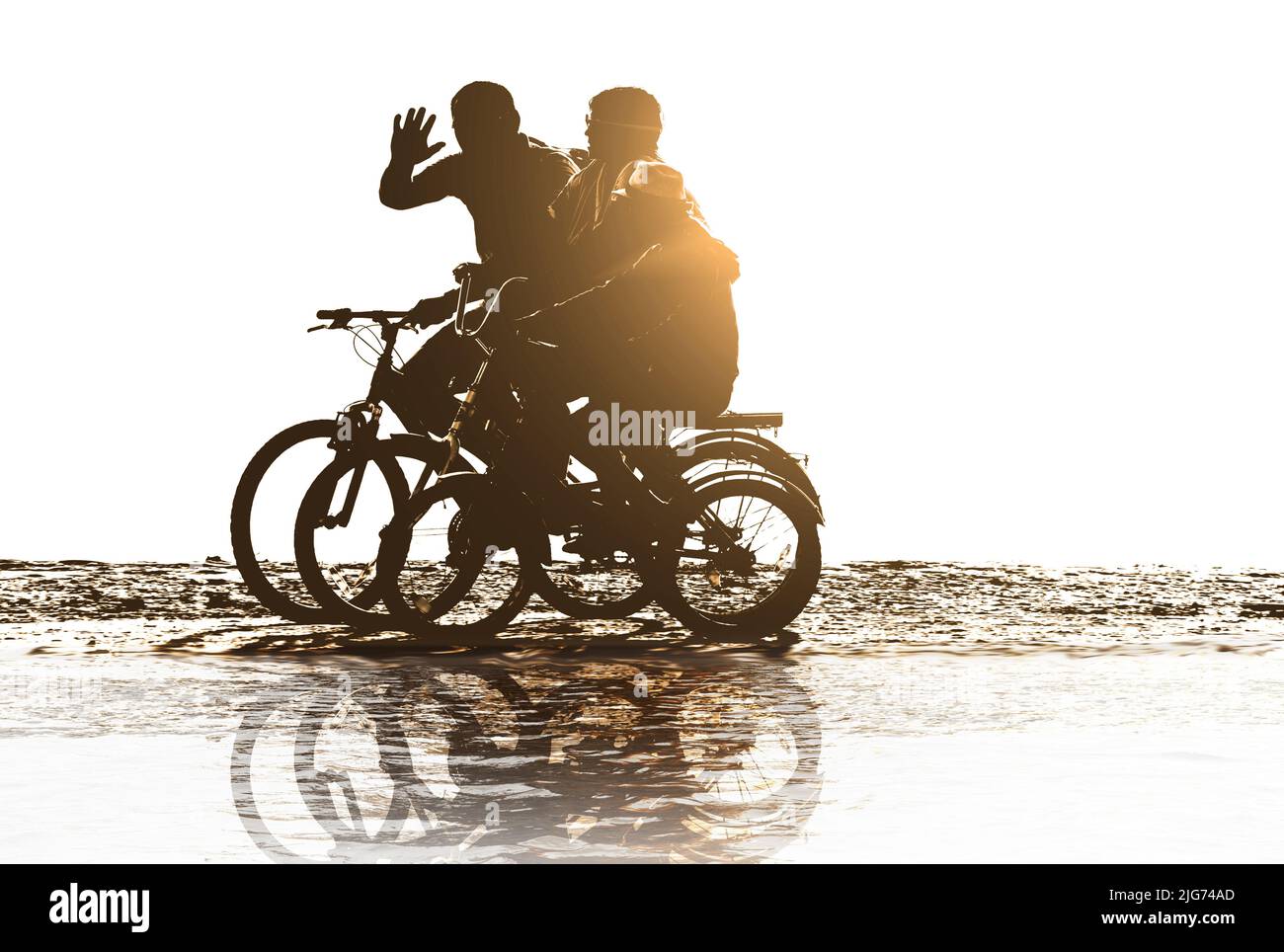 positive family rides bicycles on beach Stock Photo