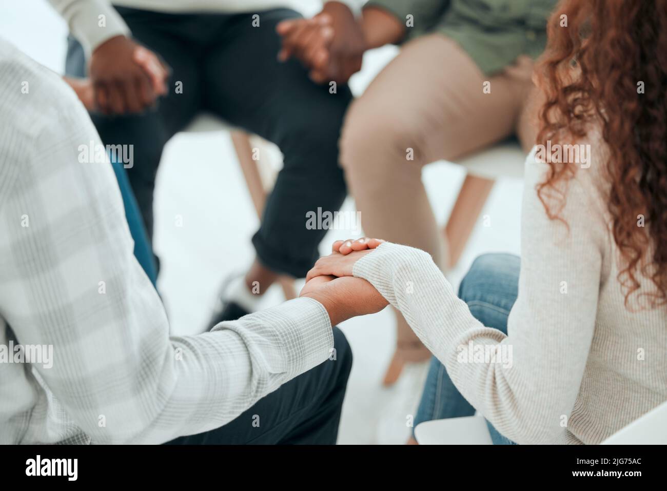 Offering up our prayers. Cropped shot of an unrecognisable group of people sitting together and holding hands during prayer. Stock Photo