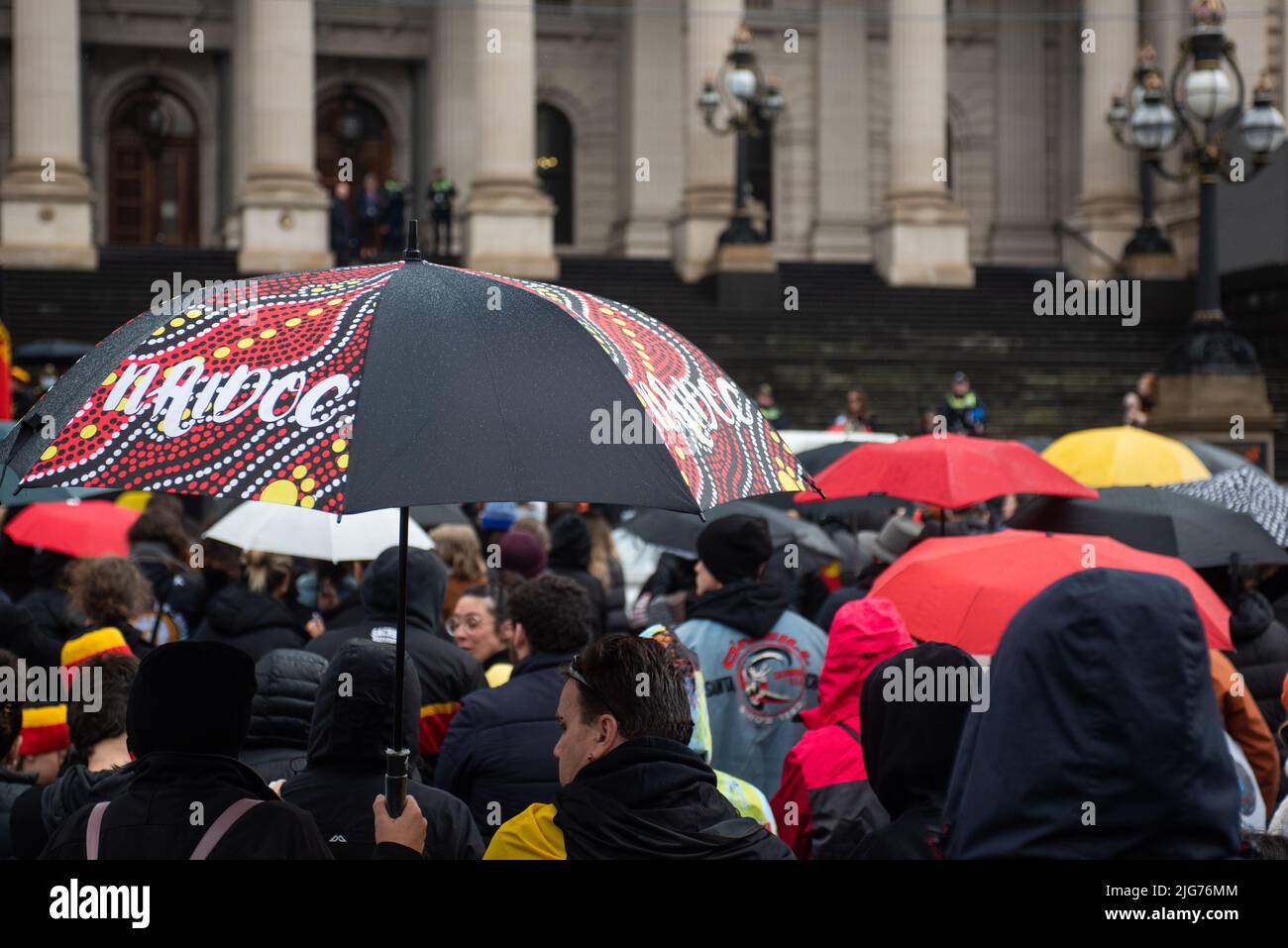 Melbourne, Australia. 8th July 2022. Those celebrating NAIDOC week outside Parliament house brave the cold and rain for a march through Melbourne. Credit: Jay Kogler/Alamy Live News Stock Photo