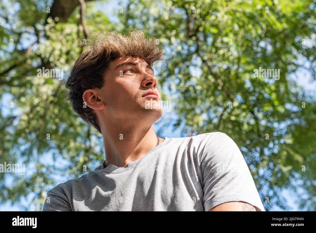 Low angle of a young man, serious in a public park Stock Photo
