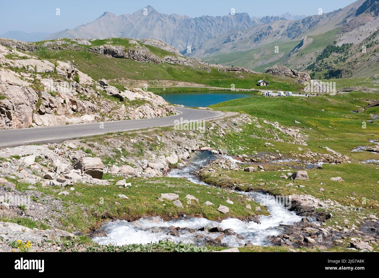 View of alpine plateau with Lac des Eissaupres next to mountain road from Route de Col de la Bonette e Restefond, in the foreground fast flowing Stock Photo